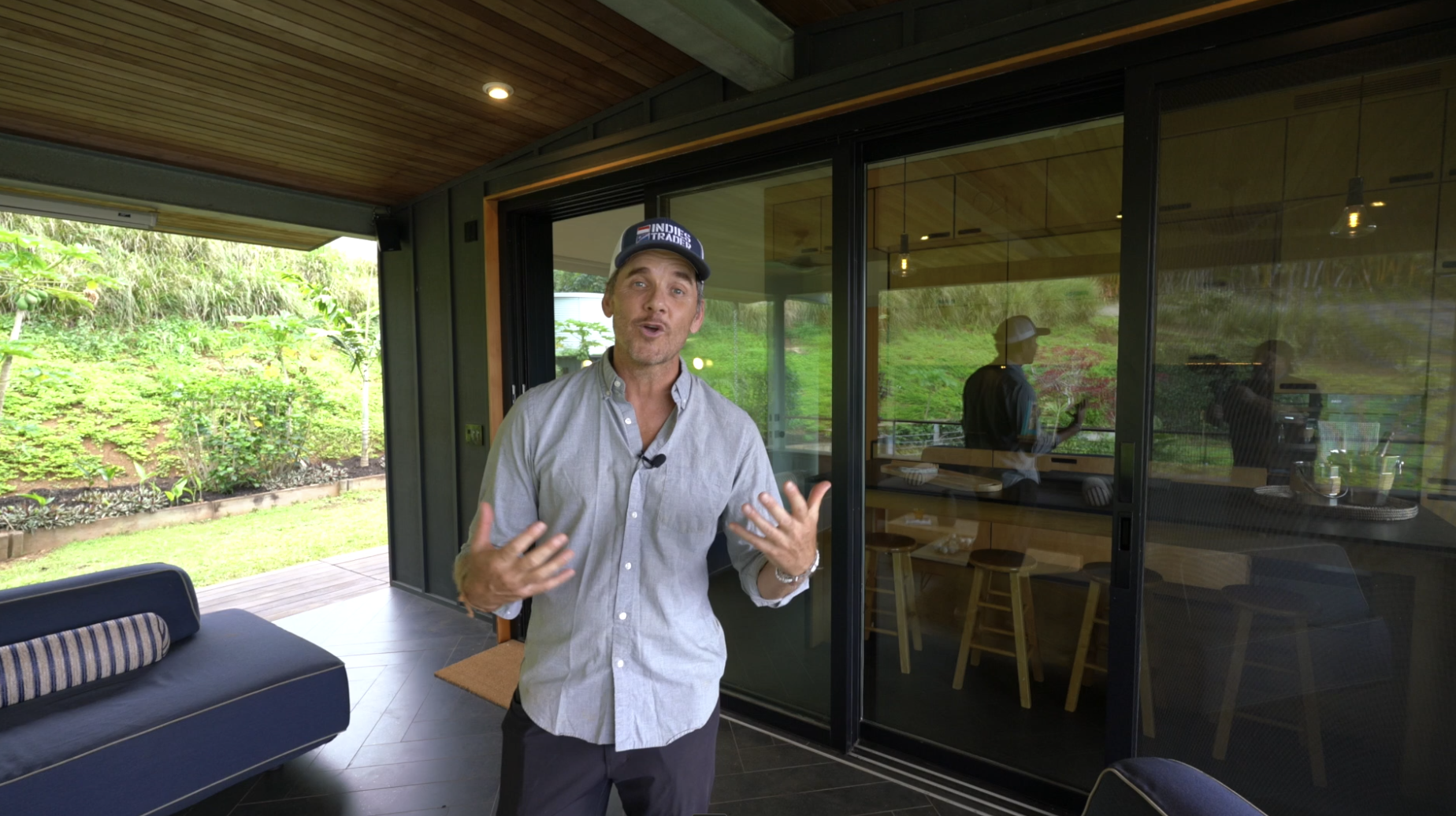 Graham Hill standing on the upper lanai, sliding doors open to the kitchen and the jungle behind him